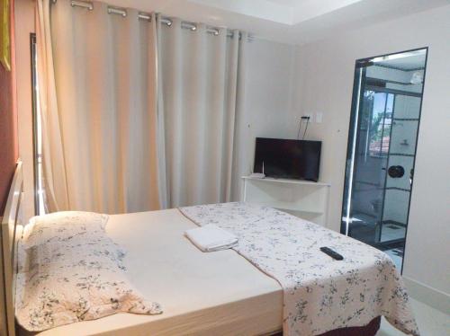 a small bedroom with a bed and a television at Casa Amaral 3 in São Pedro da Aldeia