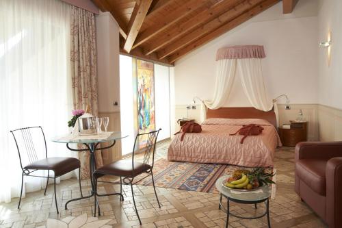 Schlafzimmer mit einem Bett, einem Tisch und Stühlen in der Unterkunft Hotel La Bussola in Orta San Giulio