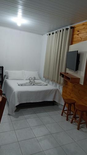 a bedroom with a bed and a flat screen tv at Casa Nas Montanhas Capixabas in Domingos Martins