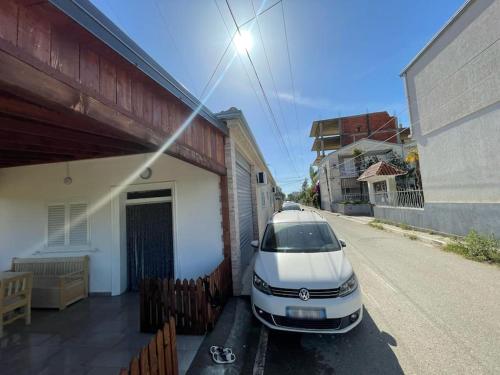 a white car parked outside of a building at Cozy 5-Bed Home with Balcony in Velipojë
