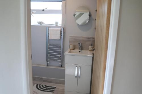 a bathroom with a sink and a bath tub at Spacious House perfect for Families & Contractors - Free Parking & WIFI By ULTIMATE HOMES AWAY in Basingstoke