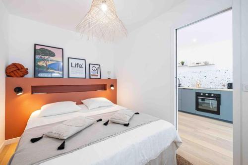 une chambre avec un grand lit et un miroir dans l'établissement 2 pièces cosy en centre ville, à Cannes