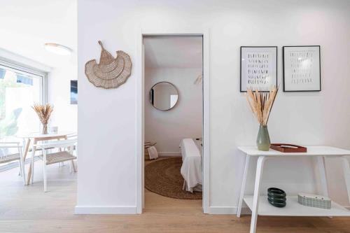 Cette chambre blanche dispose d'un miroir et d'une table. dans l'établissement 2 pièces cosy en centre ville, à Cannes