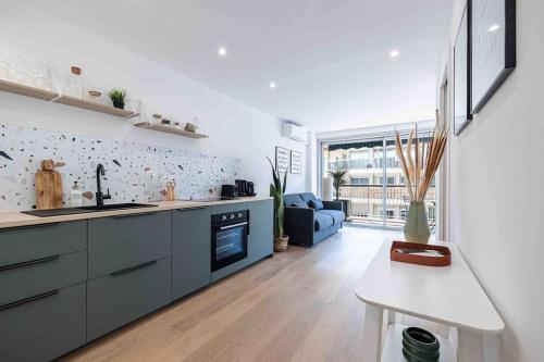 Il comprend une cuisine et un salon doté d'un canapé bleu. dans l'établissement 2 pièces cosy en centre ville, à Cannes