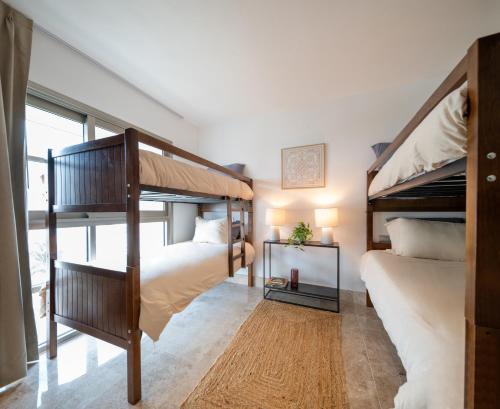 a bedroom with two bunk beds and a window at Marina Vista Retreat in Cancun La Amada in Cancún