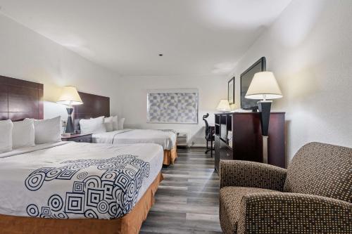 a hotel room with two beds and two chairs at Best Western Oakbrook Inn in Oakbrook Terrace