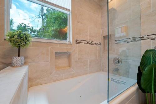 a bathroom with a tub and a window at Garden Oasis in Flamingo Park in West Palm Beach
