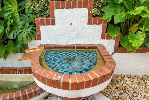 a bird bath with a fountain in a garden at Garden Oasis in Flamingo Park in West Palm Beach