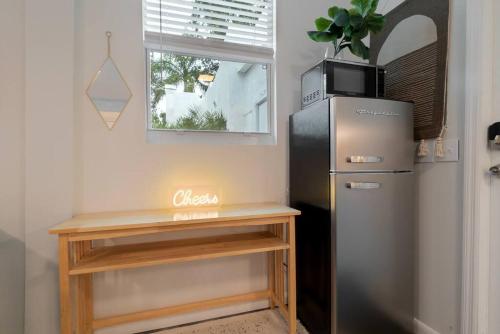 a kitchen with a refrigerator and a table and a window at Garden Oasis in Flamingo Park in West Palm Beach