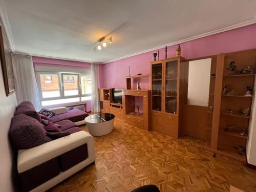 a living room with pink walls and a couch at Peris in Gijón