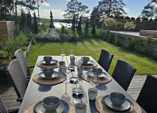 a table with plates and wine glasses on a patio at Privat Spirit Spa Villa in Vallentuna