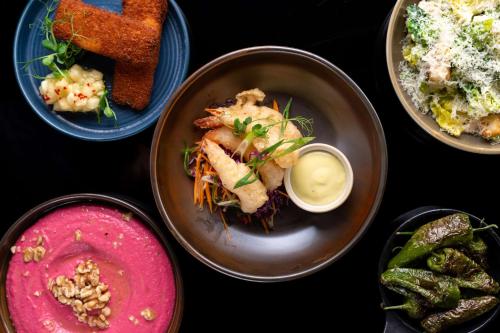 a table with four plates of food on it at Radisson Blu Hotel, Dubai Media City in Dubai