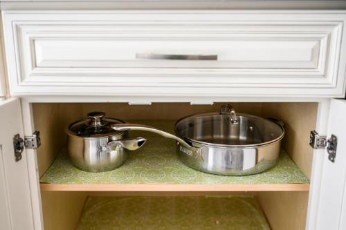 two pots and pans sitting on a shelf in a drawer at Mins to Disney Chic 3BR with Arcade in Santa Ana