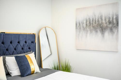a bedroom with a bed and a picture on the wall at Mins to Disney Chic 3BR with Arcade in Santa Ana