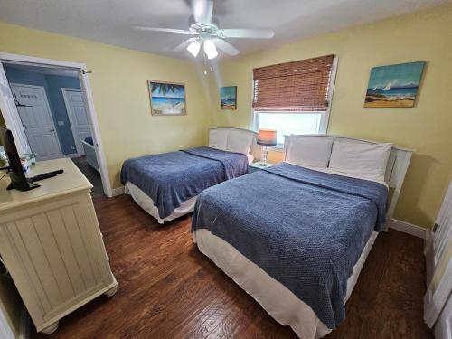 a bedroom with two beds and a ceiling fan at El Palmar Cottages LLC Whole House in Clearwater Beach
