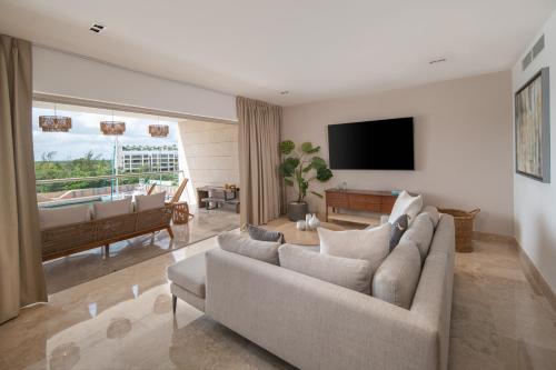 a living room with a couch and a flat screen tv at Marina Vista Retreat in Cancun La Amada in Cancún