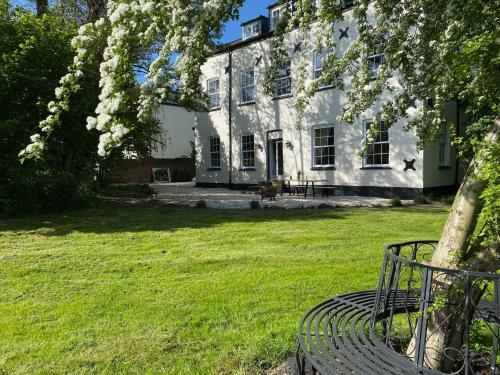 a bench in front of a house with a tree at The Old Granary in Norwich
