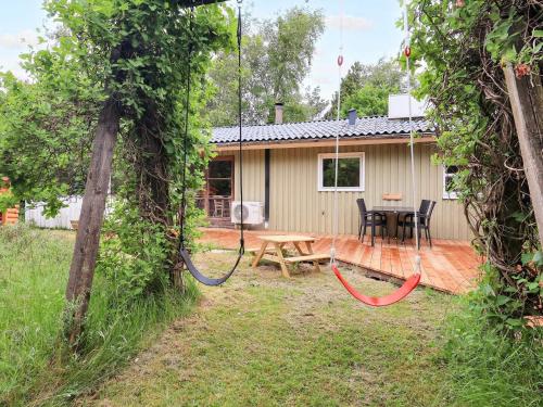 a house with a patio and a table and chairs at 6 person holiday home in Brovst-By Traum in Brovst