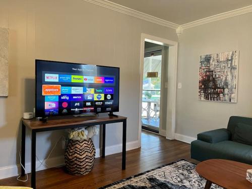 ein Wohnzimmer mit einem großen Flachbild-TV auf einem Tisch in der Unterkunft Peaceful home in downtown Huntsville with nice back patio! in Huntsville