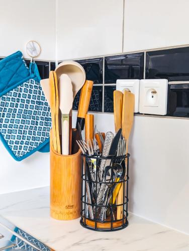une tasse d'ustensiles de cuisine sur un comptoir dans l'établissement Charment appartement 2 pièces, à Montreuil