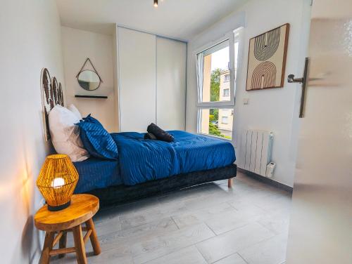 une chambre avec un lit bleu et une fenêtre dans l'établissement Charment appartement 2 pièces, à Montreuil