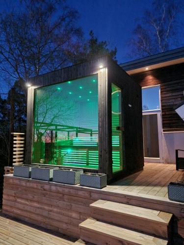 a house with a large window on a deck at Privat Spirit Spa Villa in Vallentuna