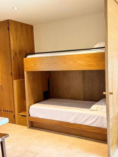 クルス・デ・ウアナカストレにあるzantamar ixchelのベッドルーム1室(白いシーツが備わる二段ベッド2組付)