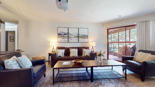 a living room with couches and a coffee table at Aspen Creek #115 in Mammoth Lakes