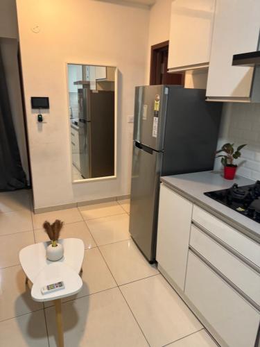 a kitchen with a stainless steel refrigerator and a small stool at Raintree in Bengaluru