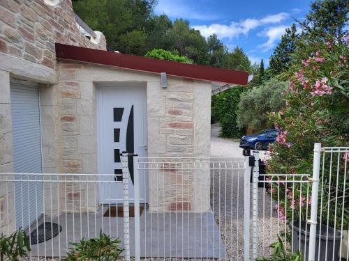 a gate with a white door in front of a building at un petit coin de paradis in Cuges-les-Pins