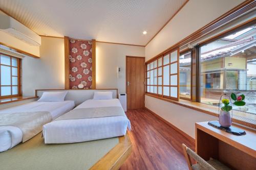 um quarto com uma grande cama branca e janelas em Ichinomatsu Japanese Modern Hotel em Takayama