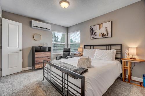 une chambre avec un grand lit blanc et une chaise dans l'établissement 10 min to Garden of the Gods-5 min to downtown, à Colorado Springs