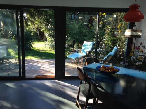 une salle à manger avec une table et des chaises en verre et une terrasse dans l'établissement La Maison Bleue, à Rezé