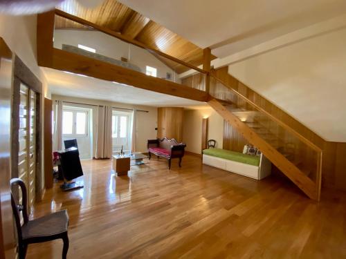 ein Wohnzimmer mit einem Loft mit Treppe in der Unterkunft Casa dos Capitães Mores - Vila Flor in Vila Flor