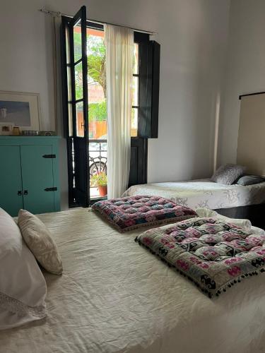 a bedroom with two beds and a window at Rincón Colonial in Colonia del Sacramento