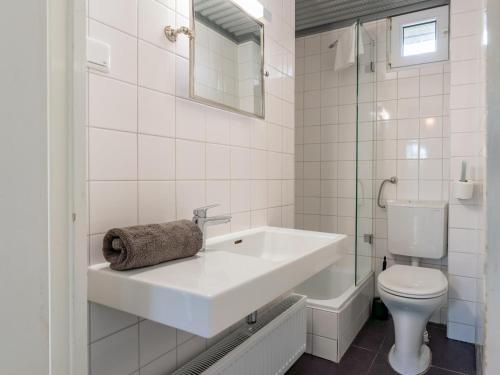 a white bathroom with a sink and a toilet at Beachhouse I in Bergen aan Zee