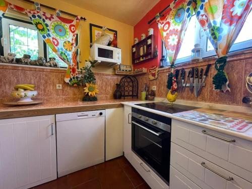 a kitchen with white cabinets and a black stove top oven at Casa da Serra - Gerês in Terras de Bouro