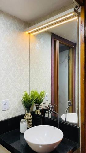 a bathroom with a white sink and a mirror at chalé das montanhas gravatal cabana águas claras in Gravatal