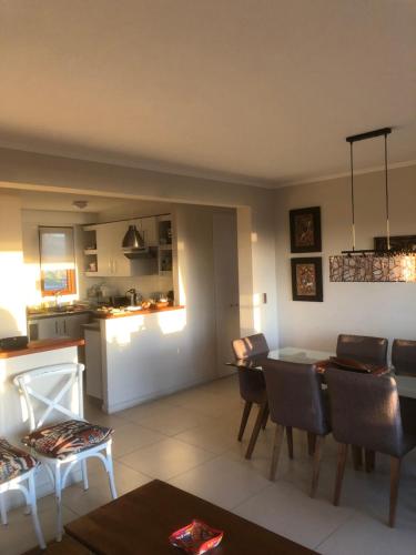 a living room and kitchen with a table and chairs at Departamento Puerto Velero in Tongoy