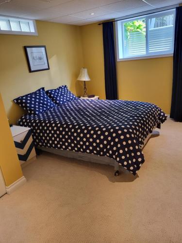 a bedroom with a blue bed with polka dot sheets at My Home in Calgary