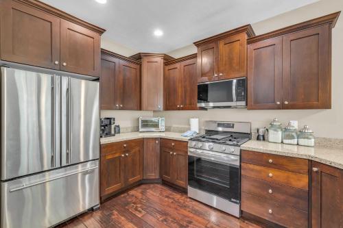 a kitchen with wooden cabinets and stainless steel appliances at Charming 3BR-Near Skiing & Hiking in Kamas