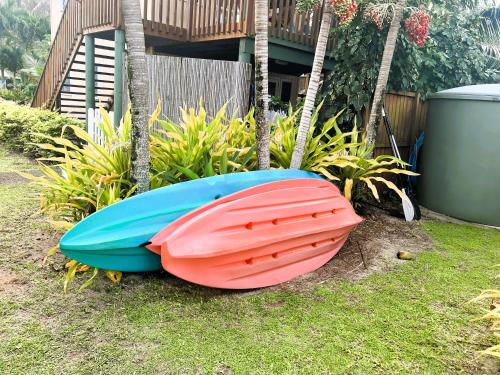 two boats sitting on the grass in front of a house at TeRito Lagoon Villas in Vaimaanga