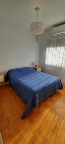 a blue bed in a room with a wooden floor at Hermoso departamento en Palermo muy luminoso in Buenos Aires