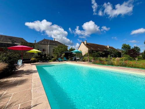 - une piscine dans une cour avec des parasols dans l'établissement Gîtes Rénovés avec Piscine au Cœur de la Brenne – Proche Sites Naturels et Historiques - FR-1-591-327, à Rosnay