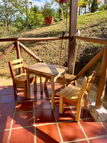 a wooden table and two chairs on a porch at Finca Turística Marquesa Wellness - Hospedaje, Desayuno y Day Spa in Curití