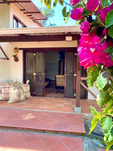 a porch of a house with pink flowers at Finca Turística Marquesa Wellness - Hospedaje, Desayuno y Day Spa in Curití