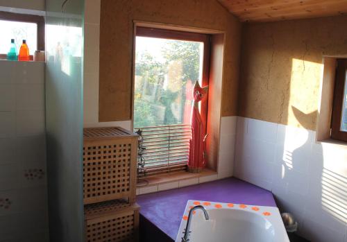 a bathroom with a window and a bath tub at Purple Papillon in Heuvelland