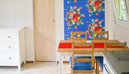 ein Esszimmer mit einem Tisch und zwei Stühlen in der Unterkunft Delta Mare - Ferienhaus Folklore - 250m zum Strand in Dziwnów