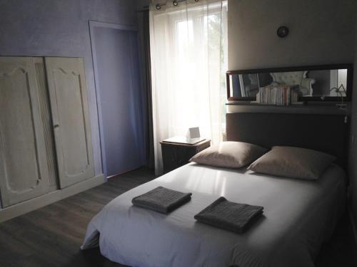 une chambre avec un lit blanc avec deux serviettes dessus dans l'établissement La Maison Bleue Trentemoult, à Rezé