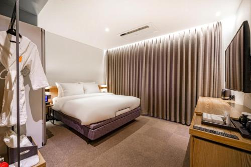 a bedroom with a bed and a large window at Haeundae The Van Hotel in Busan